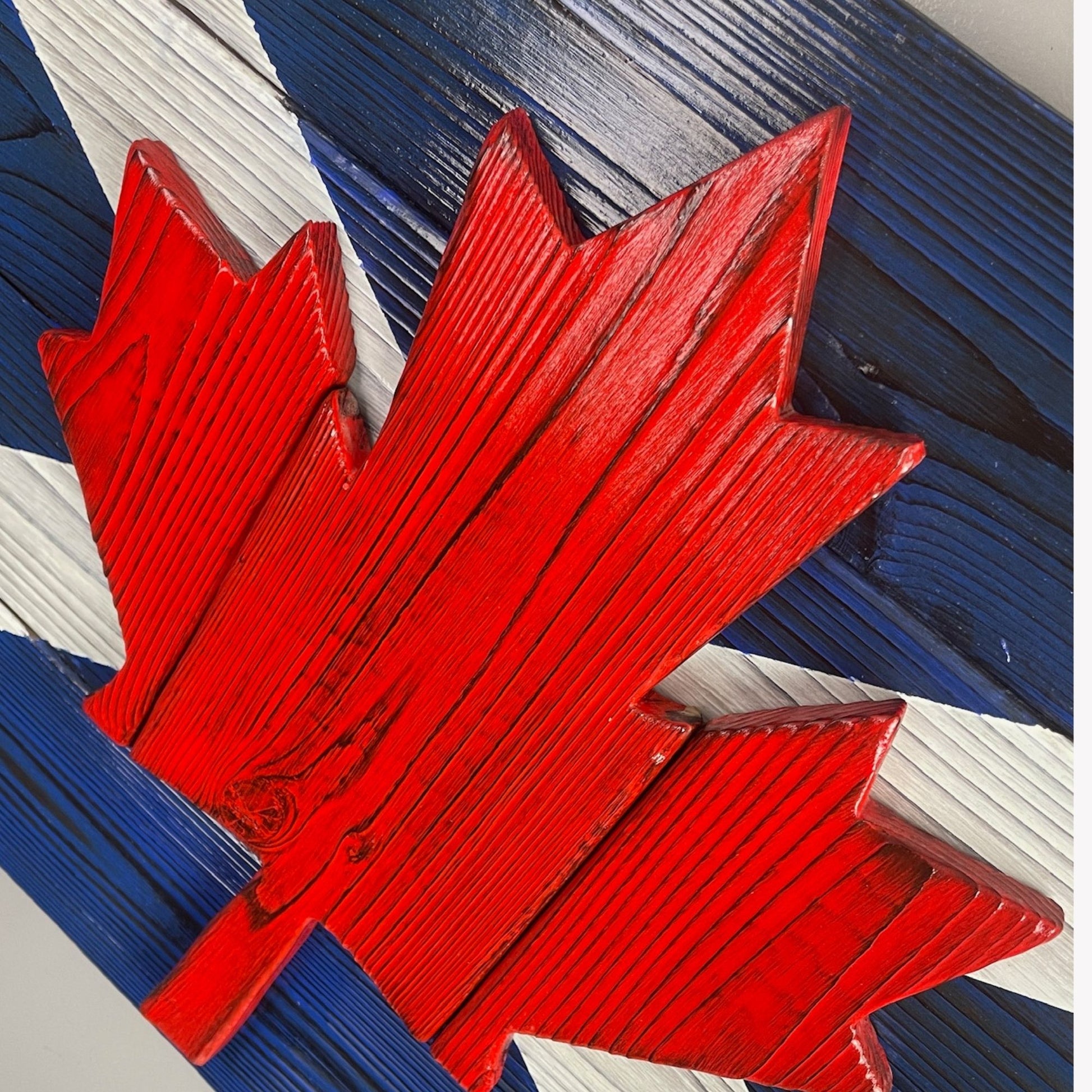 Close up Scottish Canadian wood flag showing raised maple leaf detail